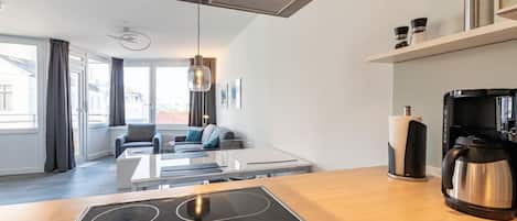 Una cocina moderna con estufa integrada, cafetera y hervidor en la encimera.