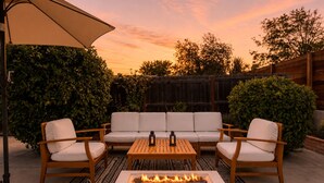 A patio with a fire pit, a sofa set, and a table. - Spacious 4BR Home w/ Cozy Fireplace, Pool & Easy Access to LA Attractions (Calabasas)
