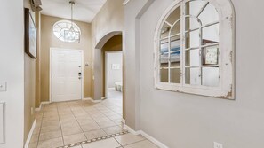 Classic hallway with a white door and arched window.