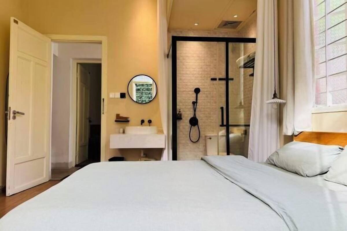 Une chambre avec un lit, une salle de bain avec une douche et des toilettes.