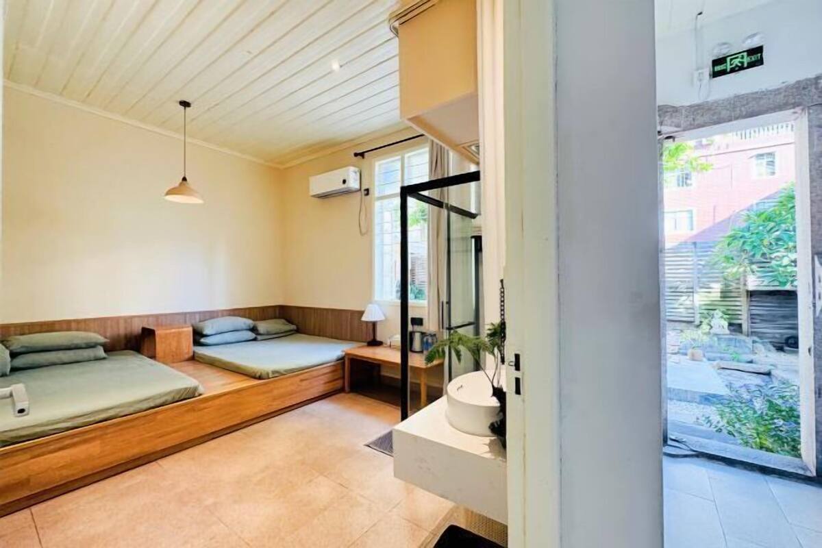 Une chambre avec un lit, un bureau, une lampe et une vue sur l’extérieur.