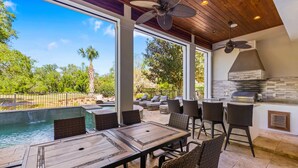 An outdoor patio with a pool, dining area, and barbecue station. - Welcome to The Dream Getaway (Kissimmee)
