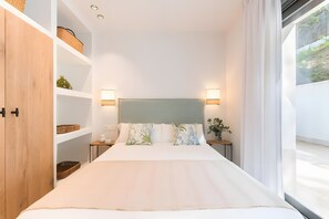 A modern bedroom with a bed, nightstands, a headboard, a wardrobe, and a window. - Villa 'Casa Rural Acogedora Y Con Estilo' with Mountain View, Wi-Fi and Air Conditioning (Málaga)