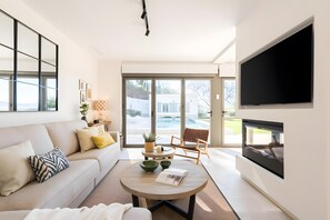 Un salon moderne avec un canapé, une table basse et un téléviseur à écran plat.