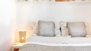 A neatly arranged bedroom with a bed, pillows, a bedside lamp, and decorative starfish on a shelf. - Villa 'Mallorquin Oasis' with Sea View, Wi-Fi and Air Conditioning (Andratx)