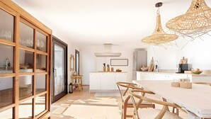 A modern kitchen with a dining area, wooden cabinets, and a large window. - Villa 'Mallorquin Oasis' with Sea View, Wi-Fi and Air Conditioning (Andratx)