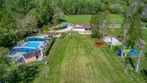 A residential property with a swimming pool, a large lawn, and a trampoline. - Mobile Home "Calvi": Holidays in Dordogne, Shared Pool & Mini-Farm near Sarlat (Bouzic)