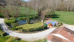 A rural property with a swimming pool, a small pond, and a fenced area with colorful barrels. - Mobile Home O'Hara 834T – Family Getaway: Shared Pools & Near Sarlat (Bouzic)