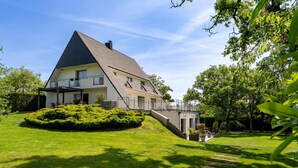 A modern house with a sloped roof, a covered porch, and a well-maintained lawn. - Kerwall – Family Rooms with Shared Pool, Private Terrace, and Wi-Fi (Malville)