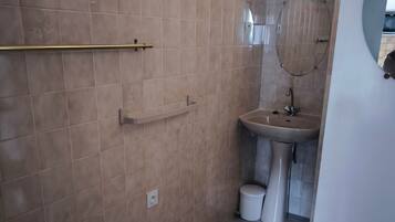 Un baño con inodoro, lavabo y cabina de ducha.