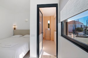A hotel room with a bed, a window, and a view of the street. - Holiday Home 'Rooftop Retreat' with Sea View, Wi-Fi and Air Conditioning (Castro Marim)
