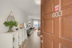 A hallway with a wooden door labeled '603' and a white shelf with decorative items.