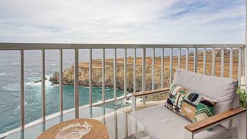 Un balcón con vista al mar y acantilados rocosos.