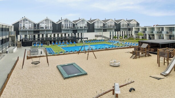 A hotel with a swimming pool, outdoor seating, and a playground. - Holiday apartment near Bønnerup (Glesborg)