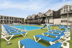 A pool area with blue lounge chairs and a swimming pool.