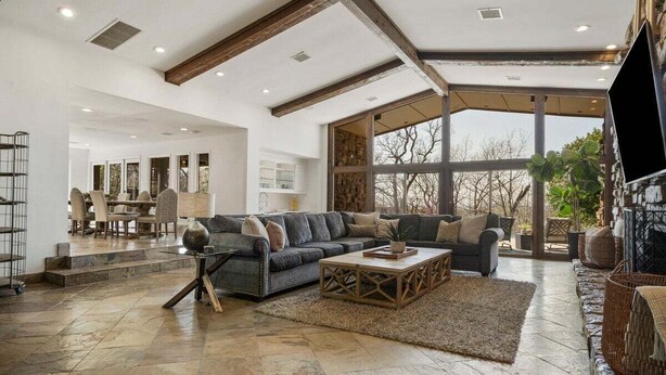 A spacious living area with a large sofa, coffee table, and a view of the outdoors. - Grotto @ Southern Hills W/Pool & Hot Tub (Tulsa)