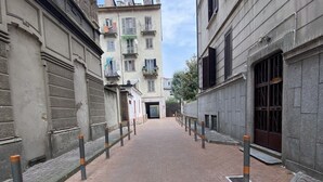 A narrow brick-paved street flanked by buildings with balconies and windows. - Bed2Go Brescia (Turin)