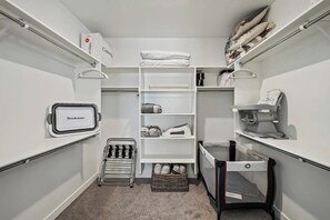Ein kleiner, übersichtlicher Kleiderschrank mit Regalen, einem Wäscheständer und einer Aufbewahrungsbox.