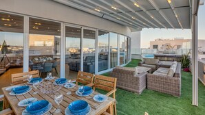 A rooftop terrace with a dining area, seating, and a view of the cityscape. - Beautiful Penthouse with pool and terrace (Is-Swieqi)