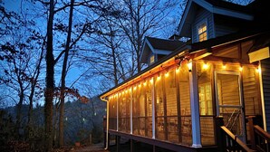 Ein Holzhaus mit einer überdachten Veranda in der Abenddämmerung.