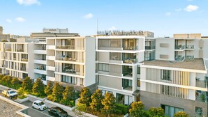 A modern multi-story building with balconies and large windows, located at 511/5A Whiteside St.