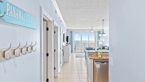 A hallway with a sign reading 'PANAMA CITY BEACH' and a view to the ocean. - Beachfront Condo w/ Ocean Views + Pool Access + Beach Gear Emerald Isle 808 by Avantstay (Panama City Beach)