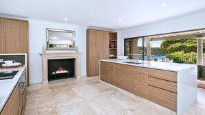 Una cocina moderna con chimenea, armarios de madera y una isla grande.