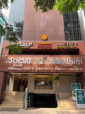 A hotel with a sign for 'Andhra Kitchen' and 'Nandhini Deluxe Banquet Hall'.
