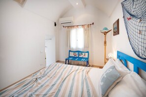 Ein Schlafzimmer mit einem Bett, einer Bank, einer Lampe und einem Netz an der Wand.