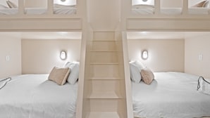 Une chambre d’hôtel avec deux lits, un escalier central et un éclairage intégré.