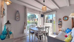 A cozy room with a dining area, a sofa, and a view of the outdoors. - Apartment in Calella near the Beach (Calella de Palafrugell, Llafranc)