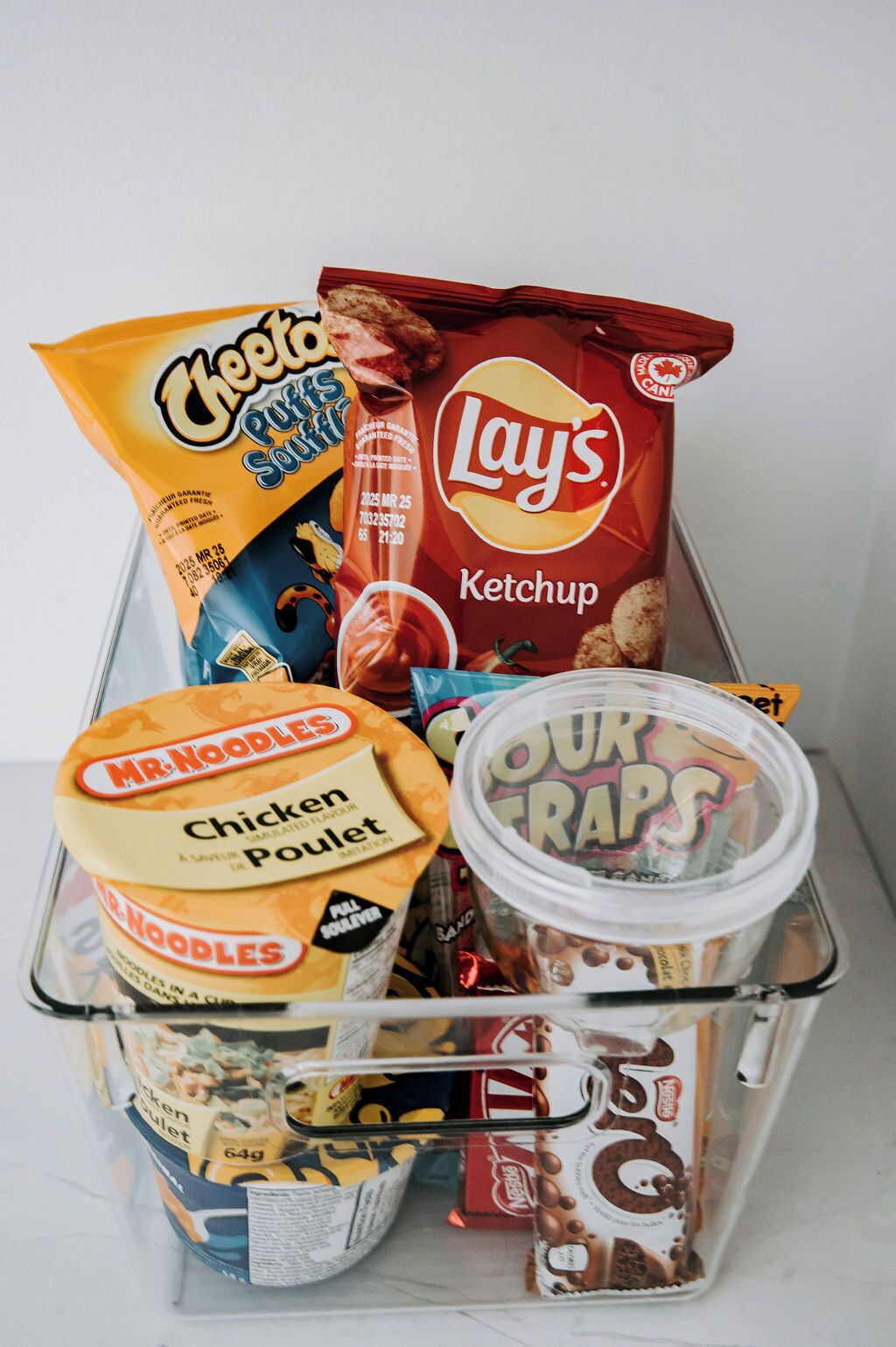 A variety of snack items including Lay's Ketchup, Mr. Noodles Chicken Pullet, and Four Traps.