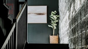 A staircase with a dark railing, a wall-mounted picture, and a potted plant. - M2 - Double Queen room #4 (Dalhousie)