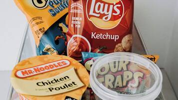 A variety of snack items including Lay's Ketchup, Mr. Noodles Chicken Pullet, and Four Traps.