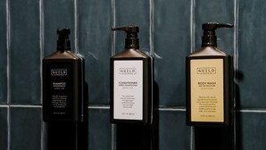 Three bottles of Guild + Pepper products against a tiled wall.