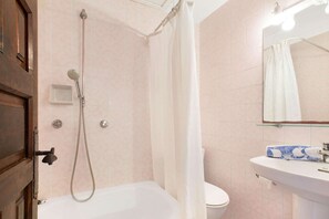 Un bagno con doccia, toilette e lavandino.