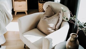 A modern bedroom with a plush armchair, bedside tables, a bedside plant, and a large window with curtains. - M2 - Spacious King Room # 3 (Dalhousie)