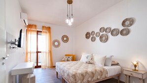 Un dormitorio con cama, mesita de noche y decoración en la pared.