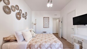 Un dormitorio con cama, televisión y armario.