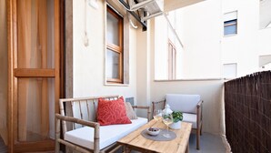 Un banco de madera con cojín y una mesa con un bol y vasos.