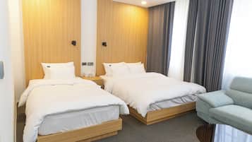 Ett hotellrum med två sängar, en soffa och ett litet bord.