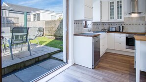 Eine moderne Küche mit weißen Schränken, einem eingebauten Geschirrspüler und einer Holz Arbeitsplatte.