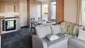Une cuisine moderne équipée d’une cuisinière, de placards et d’un coin repas avec une table et des chaises.