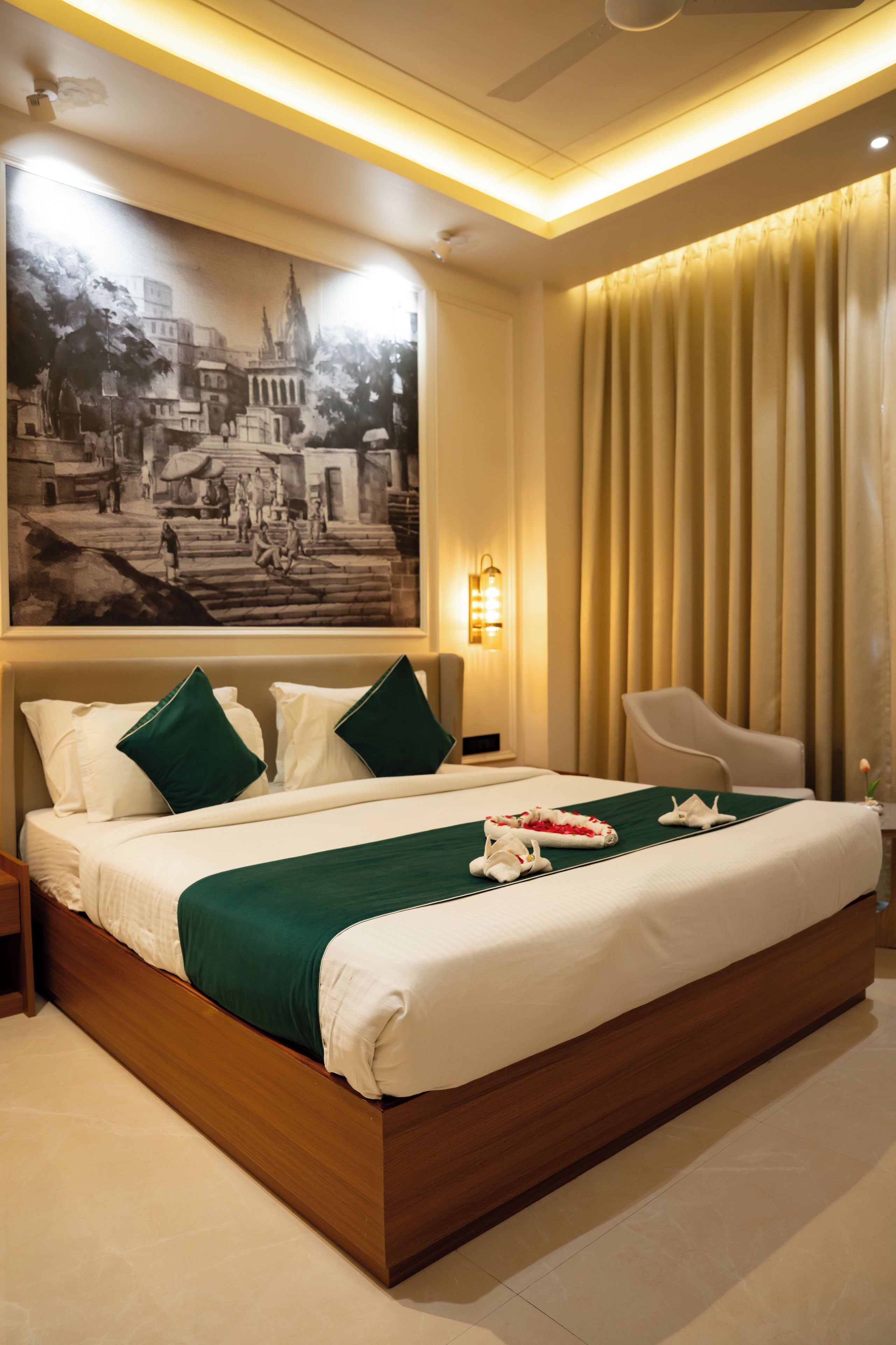 Une chambre d’hôtel avec un grand lit, une table de chevet, une chaise, une lampe fixée au mur et un grand tableau encadré.