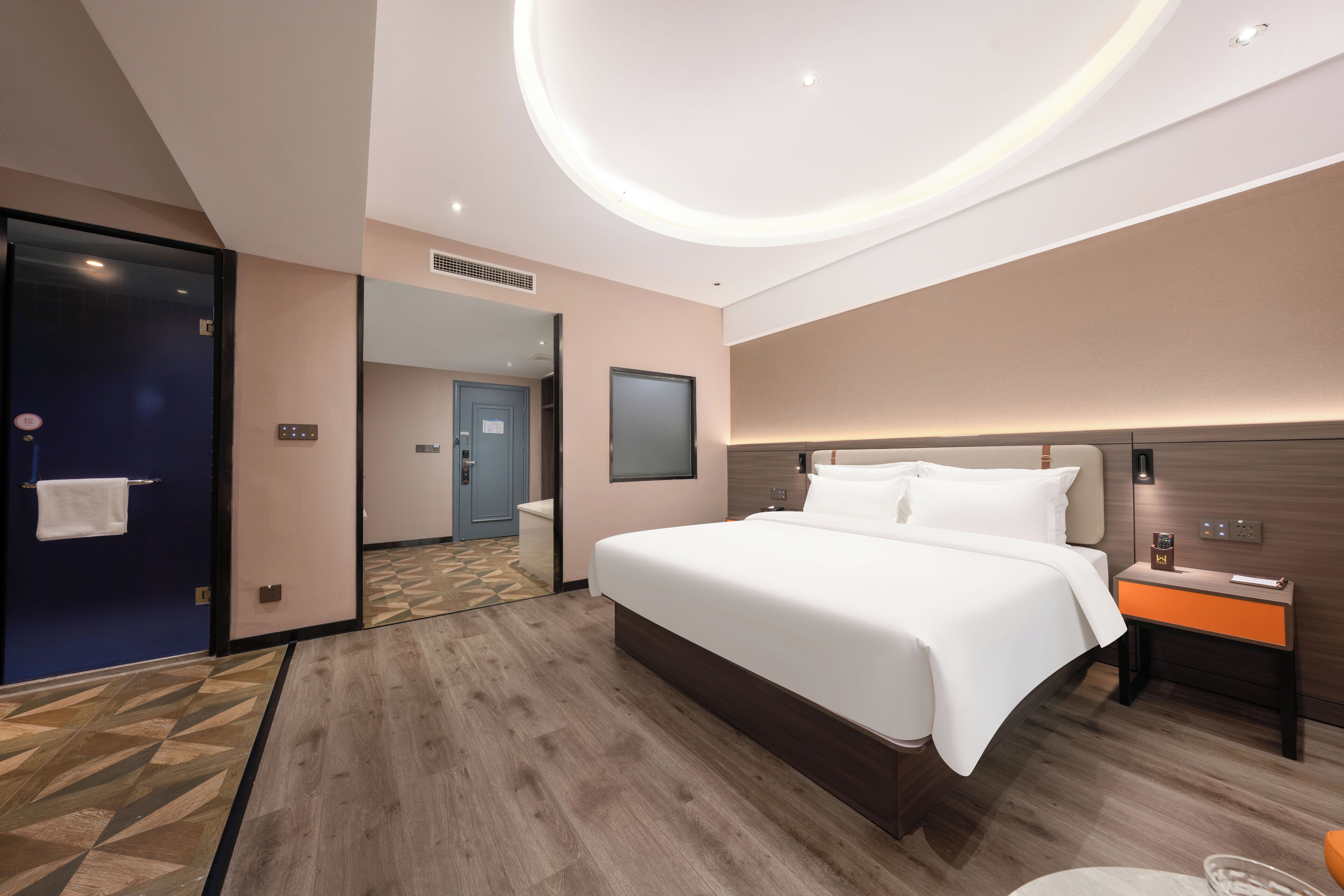 Een moderne hotelkamer met een groot bed, nachtkastje en een vastgezet hoofdbord.