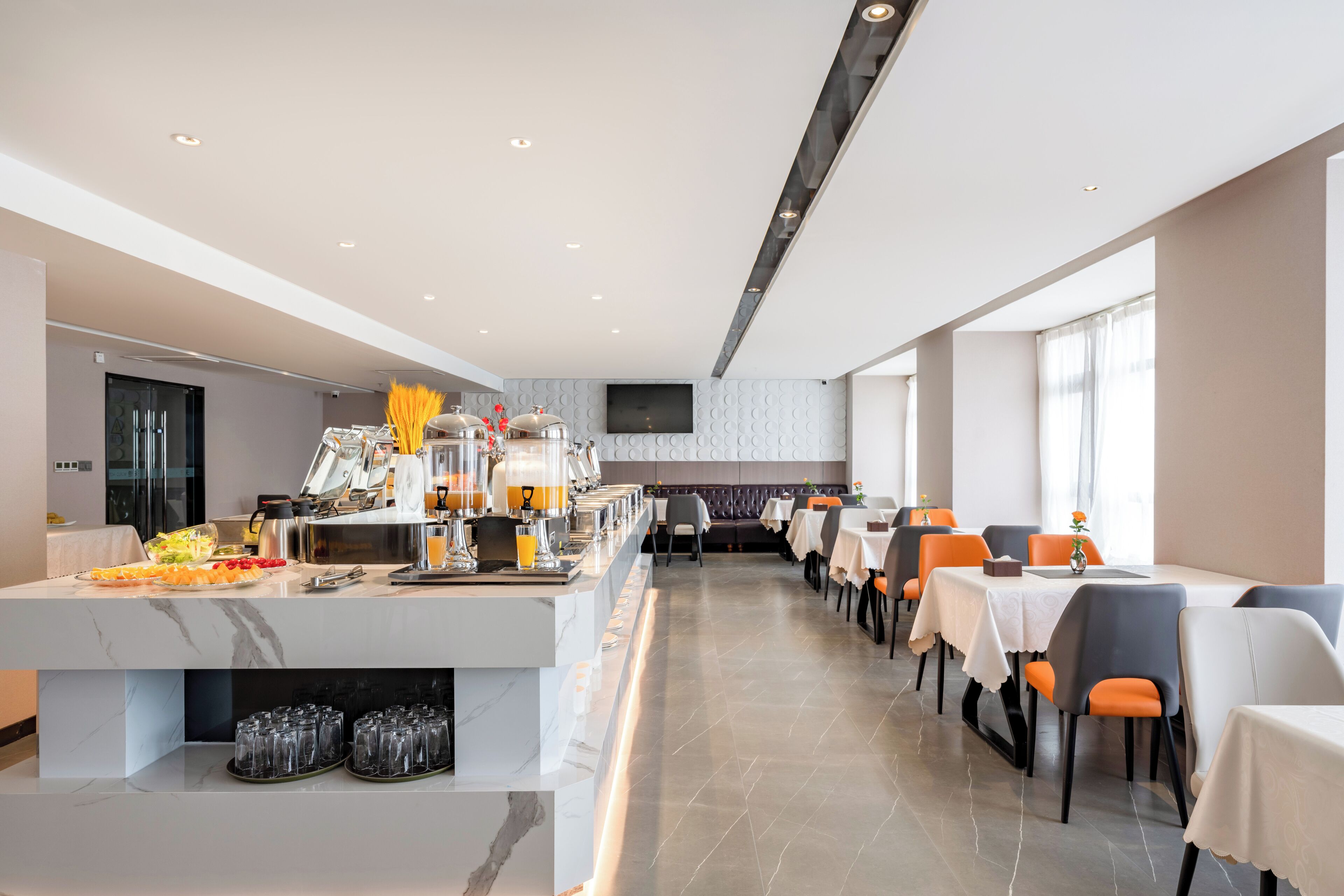 Uma sala de jantar moderna com buffet, várias mesas e cadeiras.
