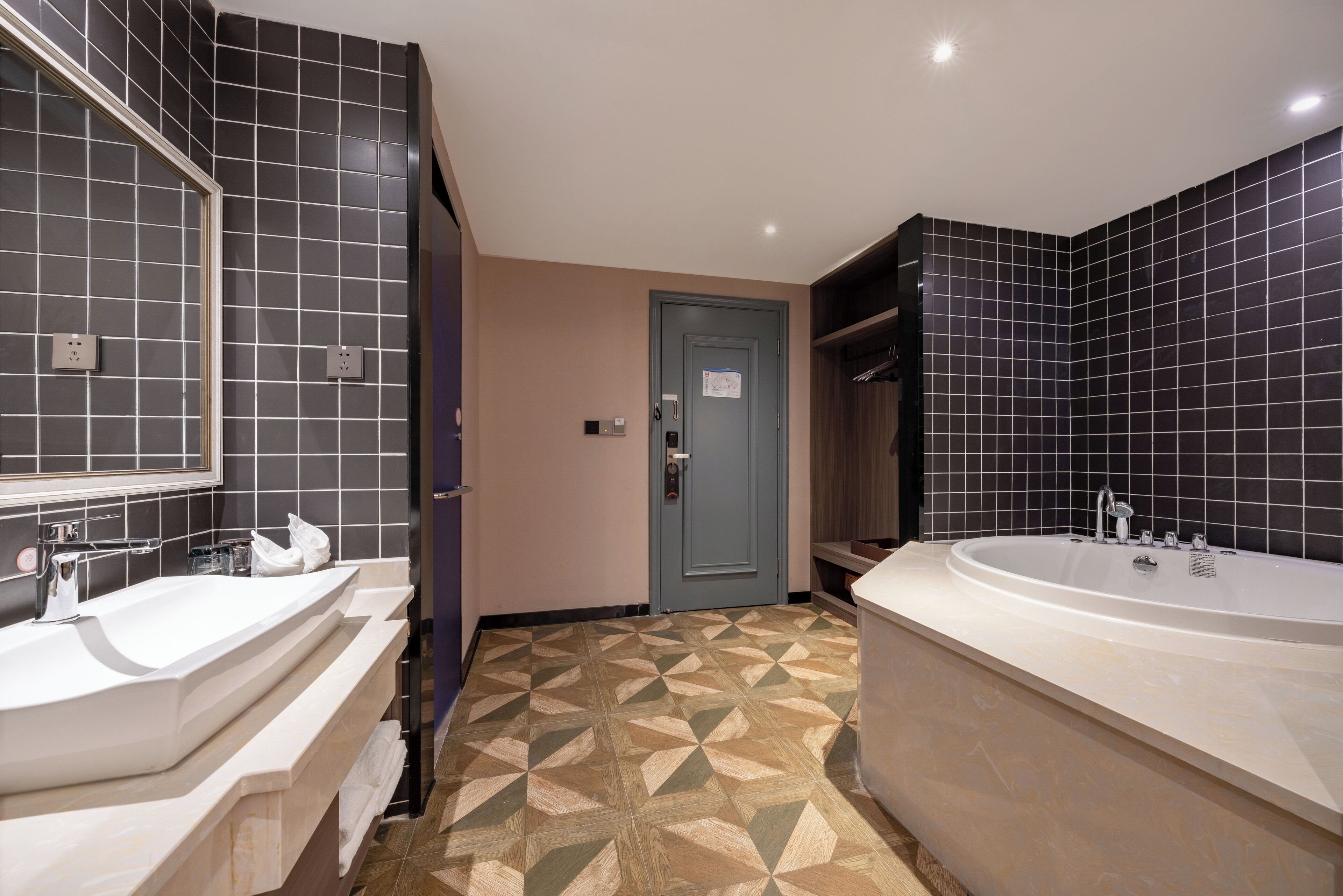 Ein modernes Badezimmer mit zwei Waschbecken, einer Badewanne und einem geometrisch gemusterten Boden.