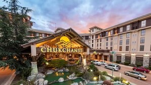 Ein Hotel mit einer großen Schrifttafel mit dem Schriftzug "CHUKCHANSI" und einem begrünten Poolbereich mit Steinen und einer Fontäne.