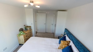 Ein Schlafzimmer mit Bett, Schminktisch und Deckenventilator.