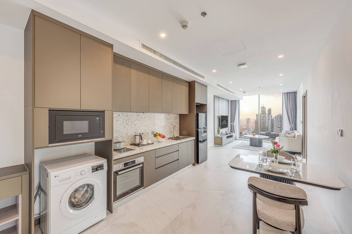 A modern kitchen with built-in appliances, a dining area with a view, and a washing machine.
